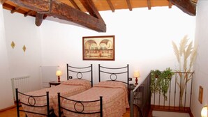 A room with two beds, a radiator, a framed picture on the wall, and a plant by the window. - Nice apartment for 6 people with pool, WIFI and TV (Canova)