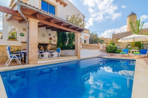 A swimming pool with lounge chairs and a patio area.