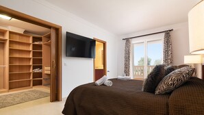 A bedroom with a large bed, a wardrobe, a flat-screen TV, and a balcony with curtains. - VILLA GLORIA - Villa with private pool in Cala Pi - Llucmajor. Free WiFi (Cala Pi)