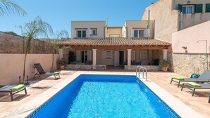 A rectangular swimming pool with a tiled edge, surrounded by lounge chairs and a stone wall. - VILLA GLORIA - Villa with private pool in Cala Pi - Llucmajor. Free WiFi (Cala Pi)