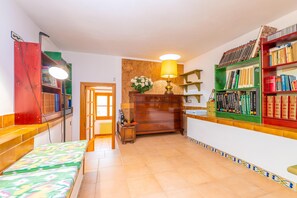 A room with a bed, a desk with a lamp, a bookshelf, and a door leading to another room. - CAN PERE VELL - Villa with private pool in ANDRATX. Free WiFi (Andratx)