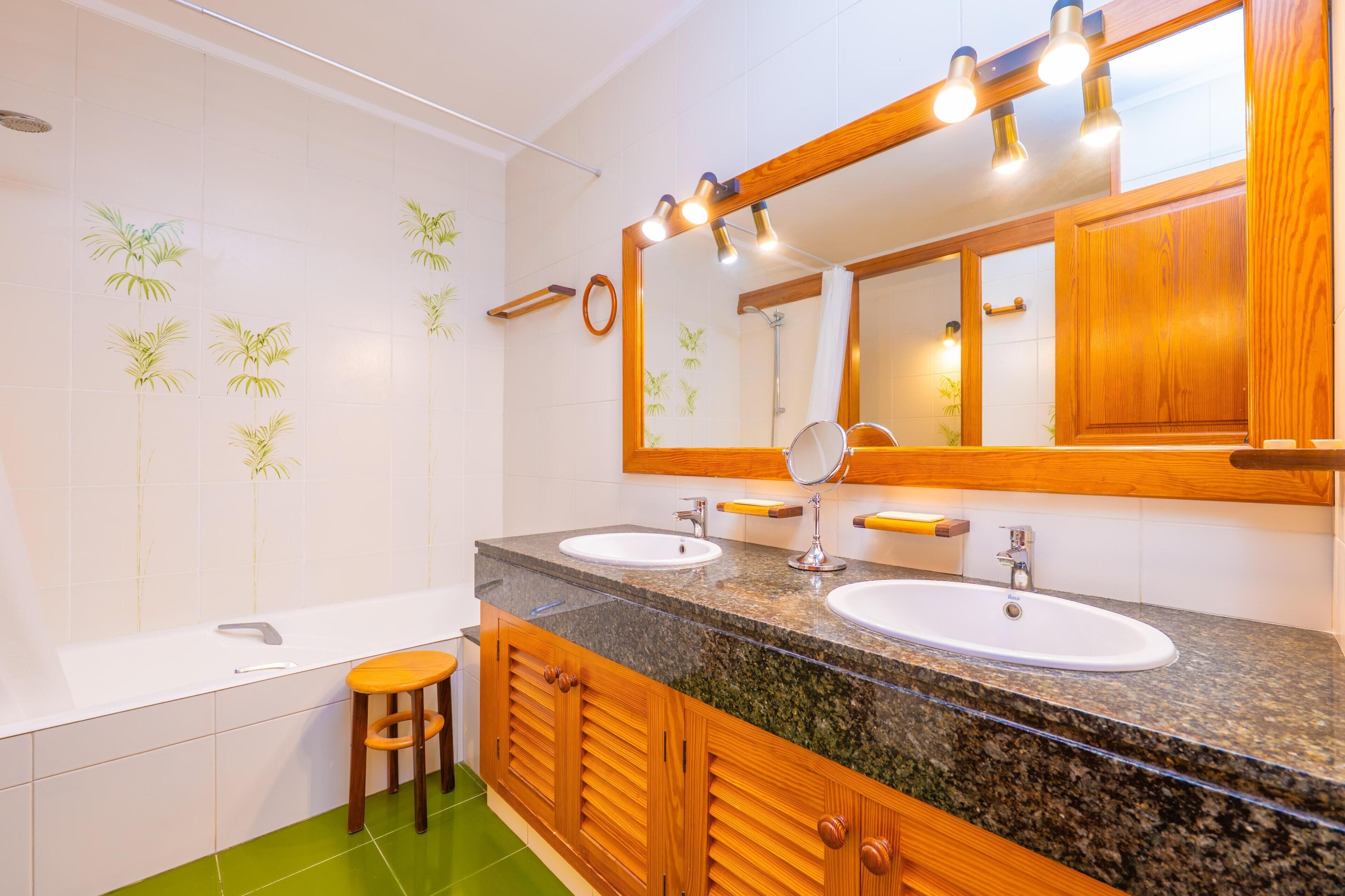 Baño con dos lavamanos, un espejo y ducha.