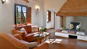 A cozy living room with a fireplace, a sofa set, and a wooden table. - Stunning private villa for 12 guests with private pool, WIFI, TV, terrace and panoramic view (Montelopio)