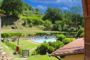 A pool area with lounge chairs and a stone wall. - Cosy apartment for 4 people with WIFI and pets allowed (Terranuova Bracciolini)