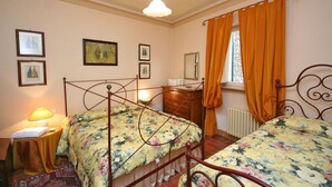 A bedroom with two single beds, a dresser, a nightstand, and a window with curtains. - Lovely apartment for 3 people with hot tub, WIFI, A/C and TV (Cortona)
