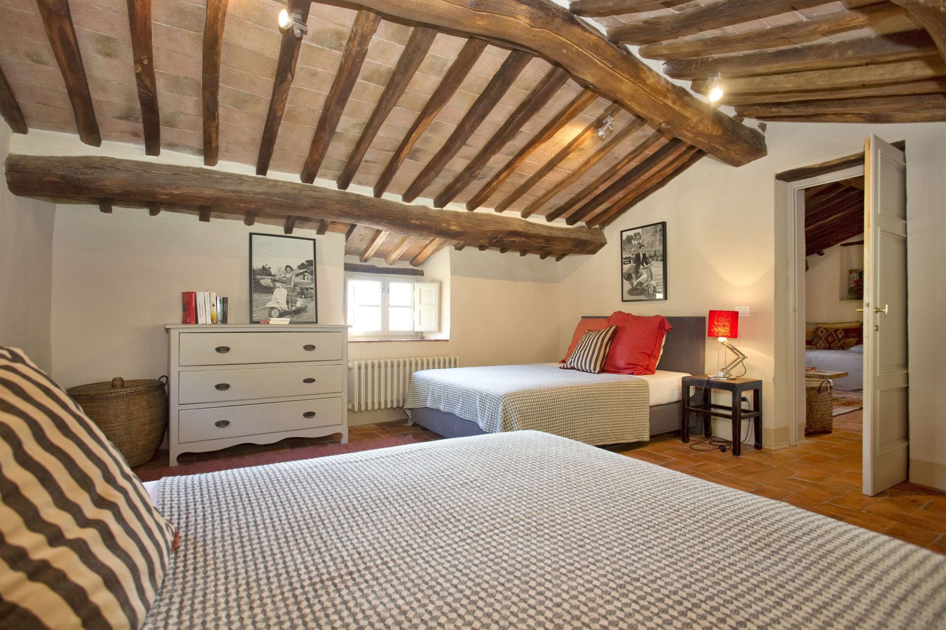 Une chambre avec deux lits, une commode, un radiateur et une fenêtre.