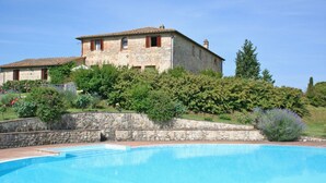 A stone building with a swimming pool in front.