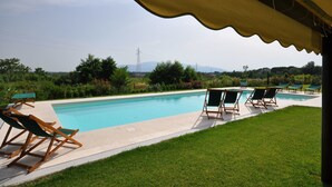 A swimming pool with lounge chairs, a grassy area, and a view of mountains and power lines in the background. - Stunning private villa with A/C, WIFI, private pool, TV, patio, pets allowed and panoramic view (Altopascio)