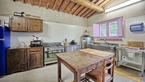 A kitchen with wooden cabinets, a gas stove, a sink, and a window with purple shutters. - Stunning private villa with A/C, WIFI, private pool, TV, patio, pets allowed and panoramic view (Altopascio)
