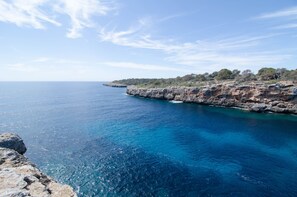 Eine Küstenlandschaft mit schroffen Klippen und klarem, blauem Meer.