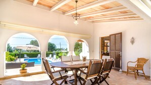 A patio with a pool, wooden furniture, and a view of the pool area. - CASA GARONDA - Beautiful chalet with private pool near the beach Free WiFi (Cala Pi)