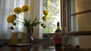 Et bord med en vinflaske, to vinglas og en vase med gule blomster.