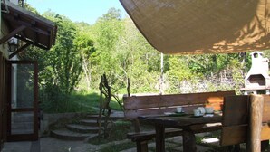A wooden bench with a table, a pergola, and a stone staircase leading to a building. - Nice apartment for 6 guests with WIFI and TV (Sassetta)