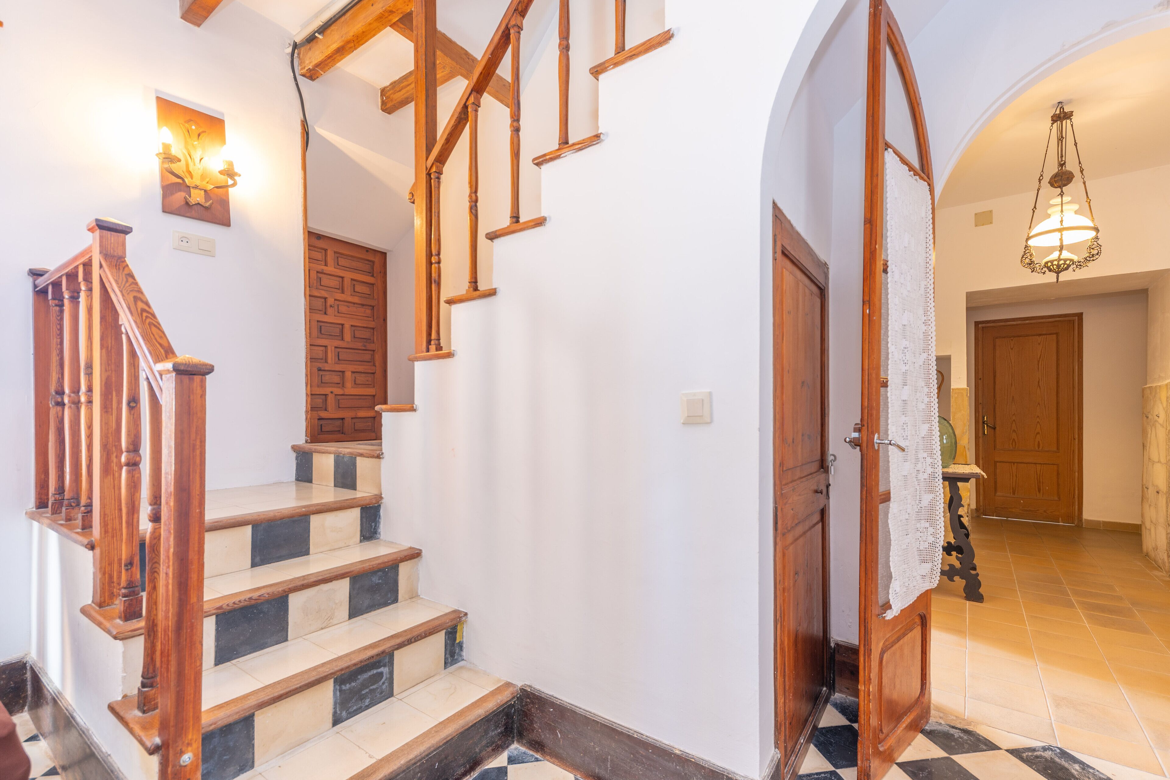 A staircase with wooden railings and a checkered floor pattern.