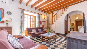 A living room with a checkered floor, a wooden staircase, a sofa, and a coffee table.