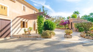 A traditional Mediterranean-style building with a courtyard, featuring a pergola, cacti, and potted plants. - CAN PUÇA - Villa with private pool in Santanyí. Free WiFi (Santanyí)