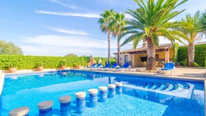 A swimming pool with blue mosaic tiles, lounge chairs, palm trees, and a building with a tiled roof. - CAN PUÇA - Villa with private pool in Santanyí. Free WiFi (Santanyí)