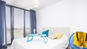 Ein Schlafzimmer mit einem Bett, einem Tisch mit einem Glas Wasser und einem Stuhl.