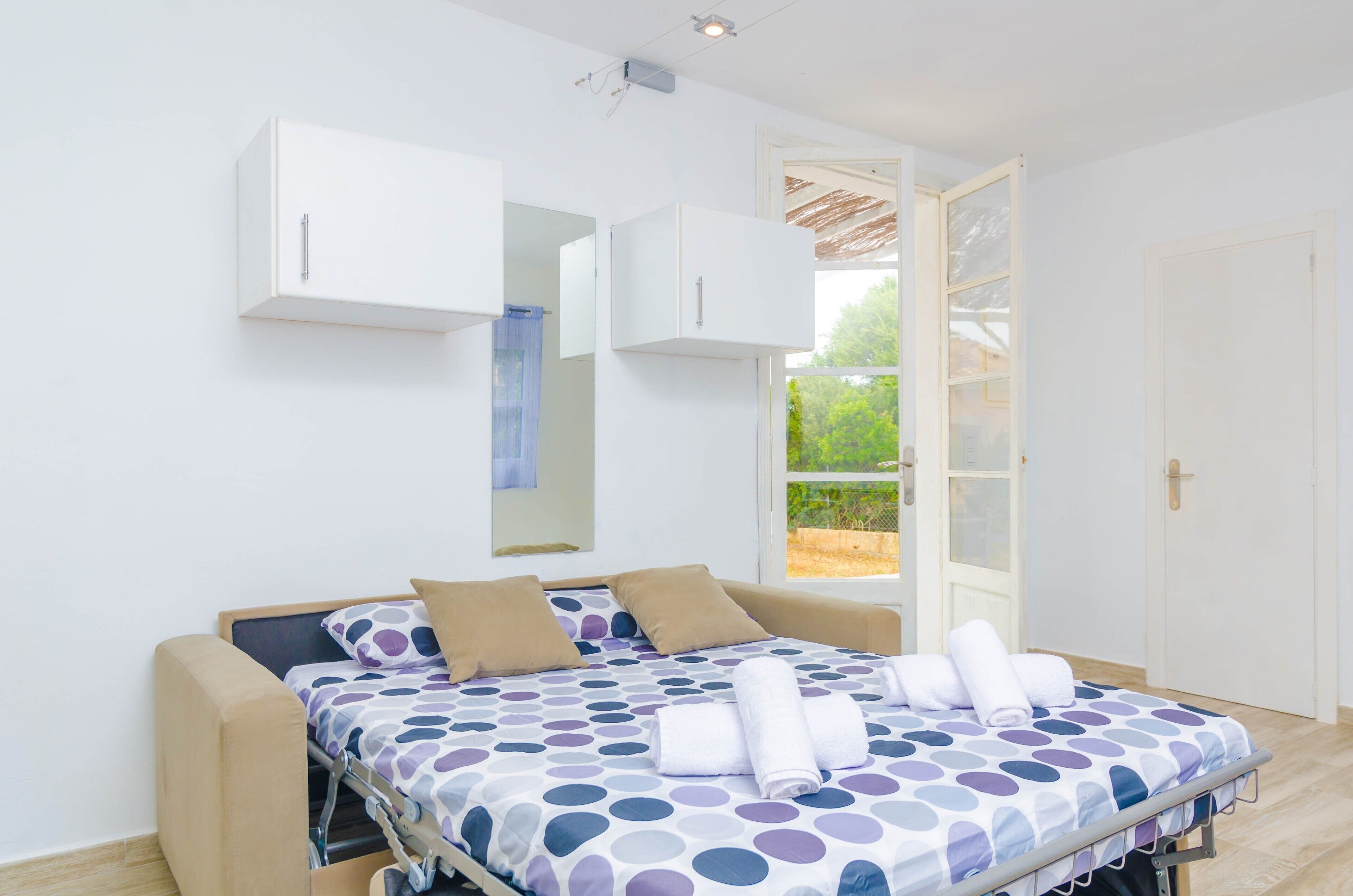 A bedroom with a bed, a window, and a door.