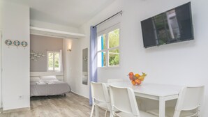 Un dormitorio con cama, ventana y baño visible a través de una puerta abierta.