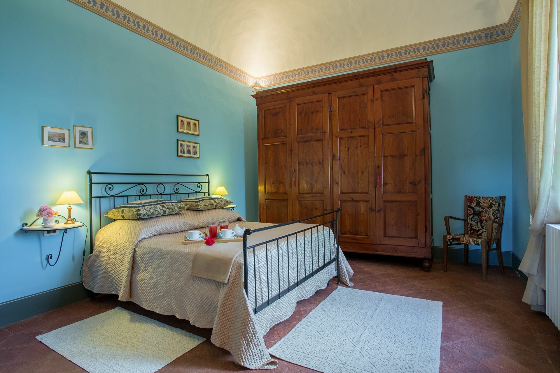 Un dormitorio con cama, mesitas de noche, un armario y una silla.