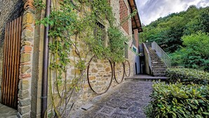 Un bâtiment en pierre avec une porte en bois, un escalier menant à un deuxième étage et un chemin pavé de pierres.