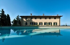 A large building with a swimming pool in front.