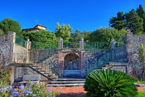 Staircase leads to an upper level surrounded by lush greenery and a clear sky.