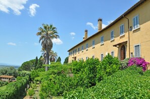 Un grand bâtiment jaune, doté de nombreuses fenêtres, avec un palmier bien visible au premier plan.