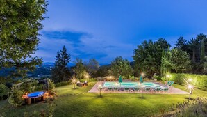 A rectangular outdoor swimming pool with lounge chairs and a hot tub, surrounded by a well-maintained lawn and trees. - Torre del Cielo - Luxury Villa with private pool (Monterchi)