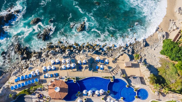 An aerial view of a resort with multiple swimming pools, beachside lounge areas, and rocky coastline. - El Encanto All Inclusive Resort at Hacienda Encantada (Cabo San Lucas)
