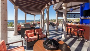 An outdoor patio area with seating, a bar, and a fire pit. - El Encanto All Inclusive Resort at Hacienda Encantada (Cabo San Lucas)