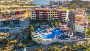 A resort with multiple buildings, a central pool area, and a view of the ocean. - El Encanto All Inclusive Resort at Hacienda Encantada (Cabo San Lucas)