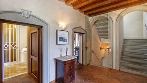 A hallway with wooden beams, a framed picture on the wall, and a tiled floor. - Villa Lucolena - Villa with private pool (Lucolena In Chianti)