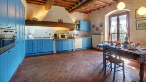 A kitchen with blue cabinets, a brick floor, and a wooden ceiling. - Villa Lucolena - Villa with private pool (Lucolena In Chianti)