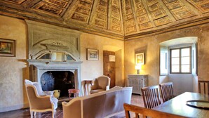 Une pièce avec une cheminée, un coin salon et une table à manger.