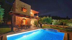 A stone building with a pool, outdoor seating, and a night sky. - Villa Nipos - Villa Rental on the Island of Crete, Greece (Vrýsai)