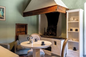 Une piÚce chaleureuse avec une table ronde, une cheminée et une bibliothÚque.
