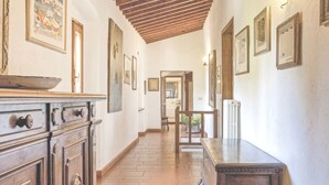 A hallway with wooden cabinets, a tiled floor, and framed pictures on the walls. - Stunning  villa for 6 people with private pool, WIFI, TV and panoramic view (Rignano Sull'arno)