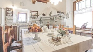 A kitchen with a dining table set for two, featuring a fruit bowl, a teapot, and a bread basket. - Stunning  villa for 6 people with private pool, WIFI, TV and panoramic view (Rignano Sull'arno)