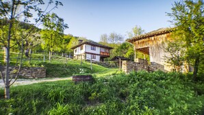 A rustic house with a stone foundation, wooden beams, and a sloped roof.