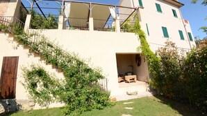 A two-story building with a covered outdoor seating area and a staircase leading to the upper level. - Wonderful private villa with A/C, WIFI, private pool, TV, veranda, pets allowed and panoramic view (Aiale)