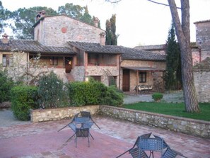 A stone building with a patio area featuring outdoor seating.