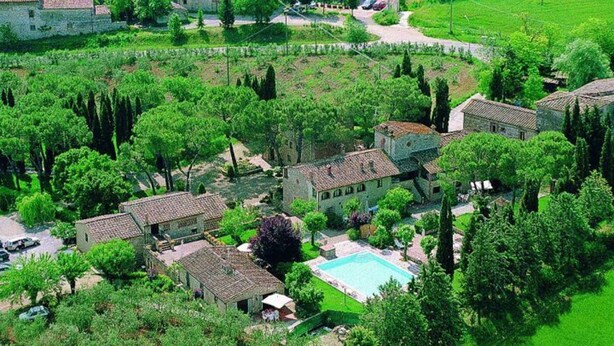 Vue aérienne d’une propriété comprenant plusieurs bâtiments, une piscine et de nombreux espaces verts.
