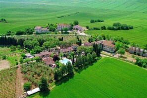 An aerial view of a rural property with multiple buildings, a swimming pool, and surrounding green fields. - Nice apartment in villa for 2 guests with pool, TV, patio and pets allowed (Colle Di Val D'elsa)