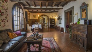 A rustic interior with a leather sofa, wooden dining table, and a green potted plant. - Private Villa with hot tub, private pool, A/C, WIFI, sauna, TV, patio, pets allowed, panoramic view (Grezzano)