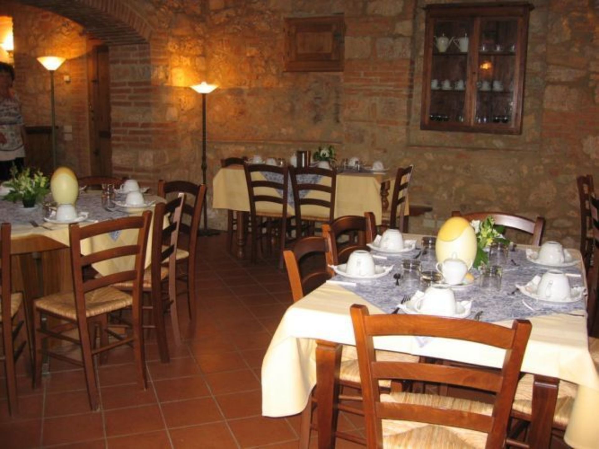 A restaurant with brick walls, wooden tables, and chairs.