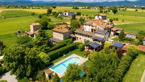 Un pueblo rural con casas de piedra, una piscina y paneles solares.