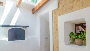 A room with a white wall, a small window with a dark frame, and a potted plant on a shelf. - SA ROTA (DEN JOAN PORRERENC) - House with terrace in Montuïri. Free WiFi (Montuïri)