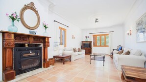 A living room with a fireplace, white sofas, a coffee table, and a television. - SA CORBAIA NOVA  - Villa with private pool in Arta. Free WiFi (Artà)
